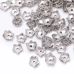 Detailed macro view of antique silver flower bead caps for DIY jewelry crafting