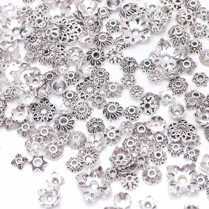 Various vintage silver hollow flower bead caps for DIY jewelry making on white background