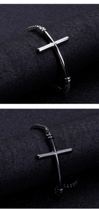 Close-up of a gunmetal stainless steel cross bracelet with a woven chain and polished finish