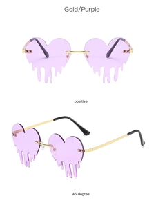 Detail view of heart-shaped rimless sunglasses in gold and purple with drip design