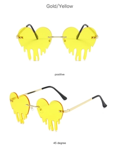 Detail of heart-shaped rimless sunglasses with gold metal frame and yellow melting teardrop lenses