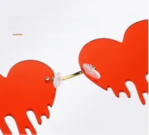 Detail of gold metal nose bridge and silicone pads on red heart drip rimless sunglasses