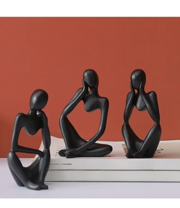 Three black abstract thinker sculptures in matte finish on books for home office decor