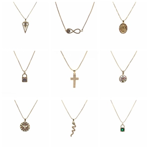 Gold necklace set featuring cross, snake, and evil eye pendants on fine chains
