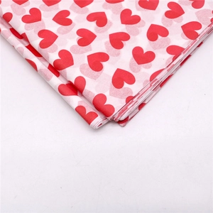 Detail von weißem Seidenpapier-Stapel mit roten Herzmustern für Geschenke