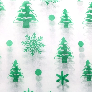 Detailed pattern of green Christmas trees and snowflakes on translucent white tissue paper