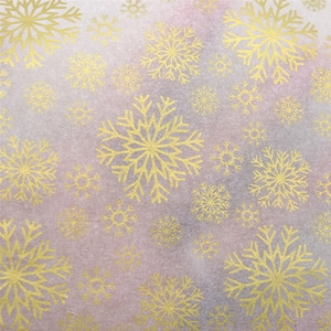 Detailed macro of pink and grey Christmas tissue paper with golden snowflake patterns