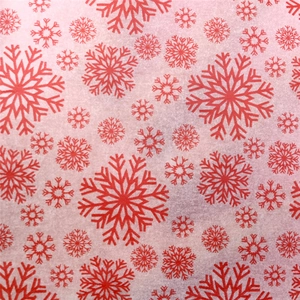 Macro shot of semi-transparent Christmas tissue paper with red snowflake patterns