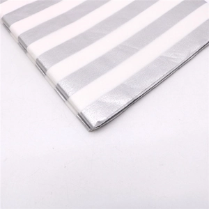 Macro view of tissue paper featuring metallic silver stripes and white striped texture