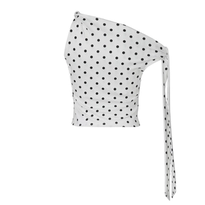 Detail of white polka dot one-shoulder top with side ribbon tie and soft fabric texture