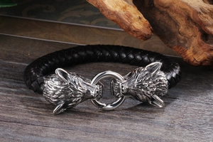 Détail d'un bracelet en cuir à double tête de loup sur un fond de bois rustique