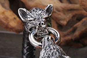 Gros plan du fermoir tête de loup en acier et bracelet en cuir noir tressé pour homme