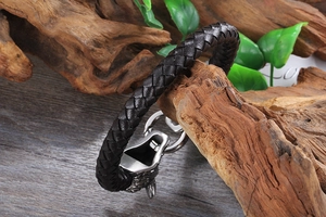 Gros plan du bracelet en cuir tressé pour homme avec fermoir loup en acier sur bois