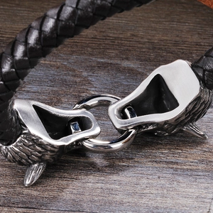 Bracelet en cuir tressé avec fermoir tête de loup en acier inoxydable sur bois rustique