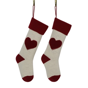 Pair of knitted Christmas stockings with red 3D hearts and loops on white background