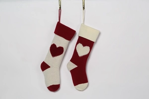 Detail of knitted Christmas stockings with 3D heart patterns and hanging loops