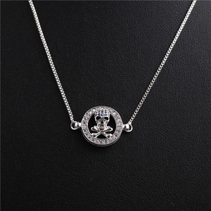 Detail of silver skull pendant with blue and clear zircon stones on a box chain necklace