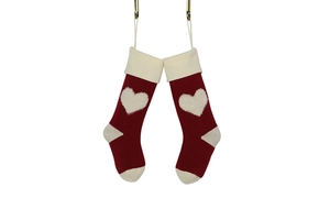 Detail of red and cream knitted Christmas stockings with white heart patterns and textures