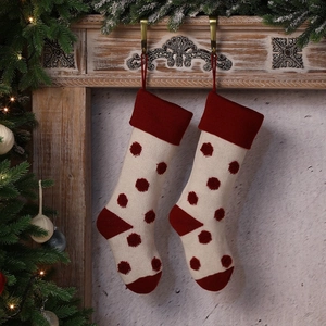 Paire de chaussettes de Noël tricotées avec pois 3D rouges et blancs sur la cheminée