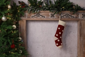 Gros plan d'une chaussette de Noël en tricot rouge à pois blancs sur une cheminée