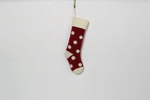 Chaussette de Noël en tricot rouge avec pois blancs 3D suspendue sur fond blanc