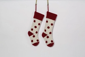 Détail de chaussettes de Noël en tricot à pois rouges suspendues aux crochets
