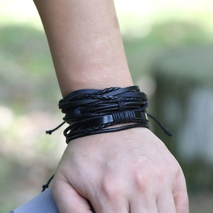 Detail of multi-layer black braided leather bracelet featuring adjustable cords on wrist