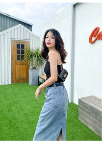 Outdoor model wearing a black quilted mini chain bag with gold hardware detail