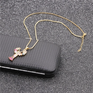 Collier doré avec un pendentif homard orné de zircons colorés sur fond de bijoux