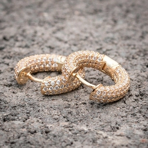 Macro detail of gold hoop earrings with pavé set cubic zirconia and hinge closure
