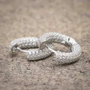 Macro shot of silver hoop earrings featuring pavé set sparkling round cubic zirconia