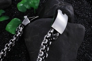 Detailed macro view of heavy-duty stainless steel links and black leather braid clasp