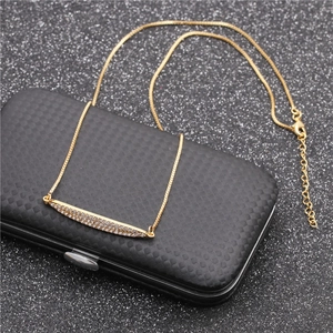 Elegant gold bar necklace with micro-pave crystals on a textured black backdrop