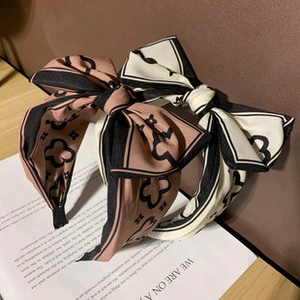 Detail of pink-brown and cream bow headbands with clover print on a vintage magazine