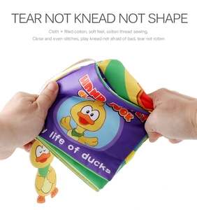Close-up showing the soft, durable texture of the baby cloth book with a yellow duck