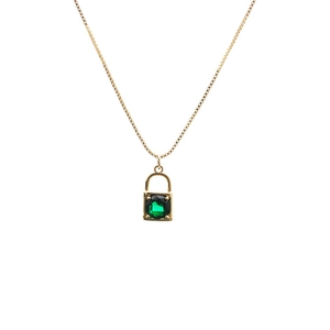 Macro shot of gold lock pendant with micro-pave emerald green gemstone on a box chain