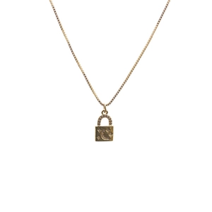 Detail of gold box chain necklace featuring a zircon-encrusted lock pendant with moon motifs