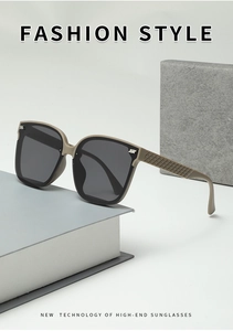 Détail de lunettes de soleil carrées beige avec branches à texture matelassée