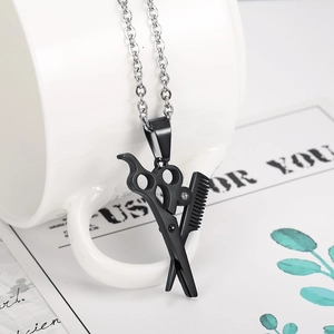 Close-up of black scissors and comb pendant necklace with diamond on a white mug