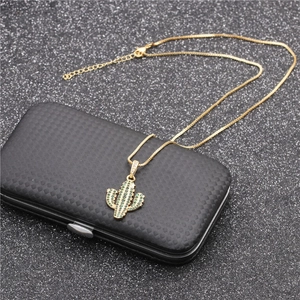 Gold cactus pendant necklace with green micro-paved zircons on black textured background