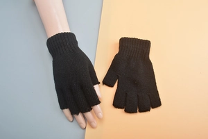 Detail of black knitted fingerless wool gloves showing texture and flexible fit on hand