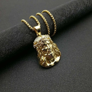 Macro shot of gold plated hip hop Jesus pendant necklace with iced out crown diamonds