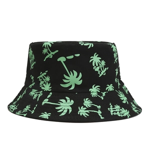 Black bucket hat with green palm tree print in a minimalist flat lay product view