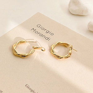 Minimalist gold twisted hoop earrings with a textured geometric design for women