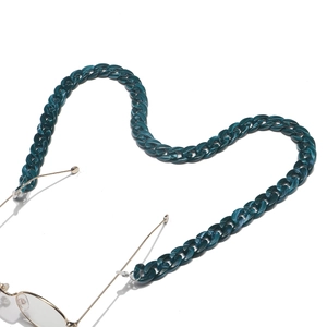 Detailed view of dark green acrylic eyewear chain with tortoise texture and gold links
