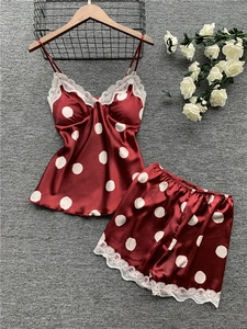 Detail of red polka dot satin pajama set with white lace trim and delicate spaghetti straps