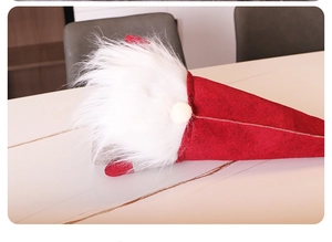 Detail of red felt gnome Christmas tree topper with white beard and soft plush textures