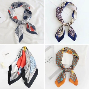 Detail showing four assorted printed silk-like square scarves with paisley and geometric patterns