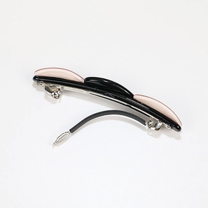 Three-row oval geometric acetate hair claw in black and pink with metal clip mechanism