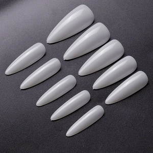 Macro shot of 10 stiletto-shaped glossy almond press-on nails in natural milky white